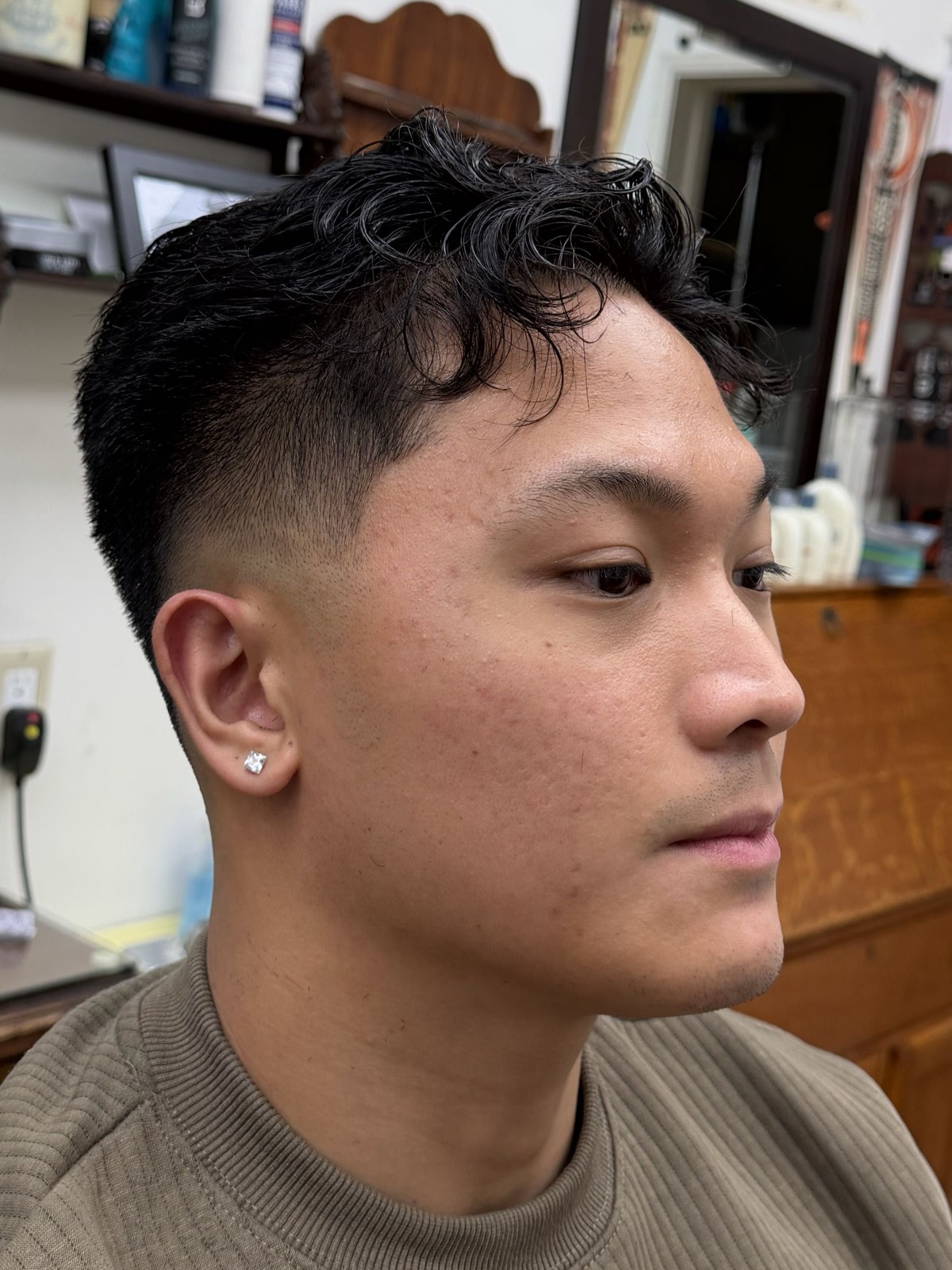 Textured fringe left long on top over a high skin fade