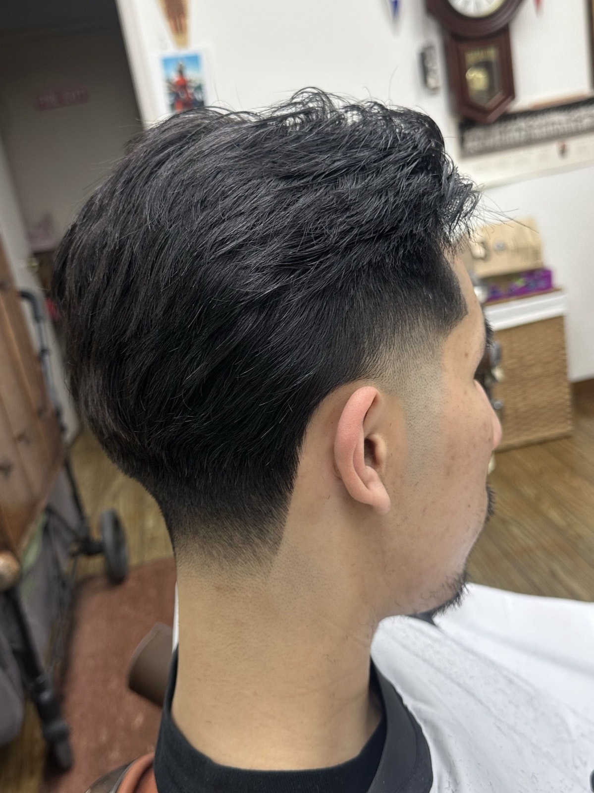 A finished textured top and low taper fade in the chair at Millbrae Barbershop